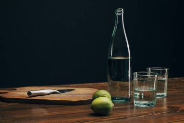 ahşap tahta bıçak, limes ve ahşap masa su şişe ile
