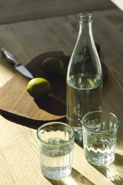 вода и лаймы для приготовления лимонада на столе
  