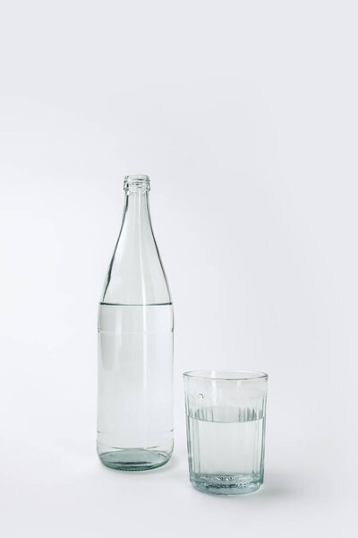 бутылка и стекло с минеральной водой изолированы на белом
 
