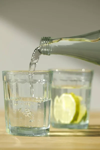 Nahaufnahme Des Gießens Von Wasser Aus Der Flasche Ins Glas — Stockfoto