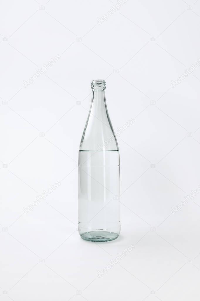 Glass bottle with calm mineral water isolated on white