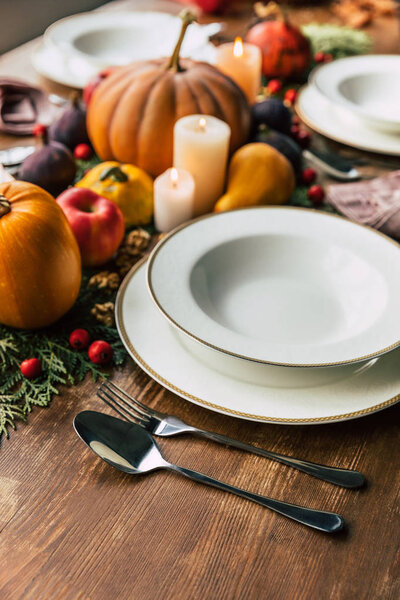 Close-up shot of table setting with beautiful autumn decor on wooden table