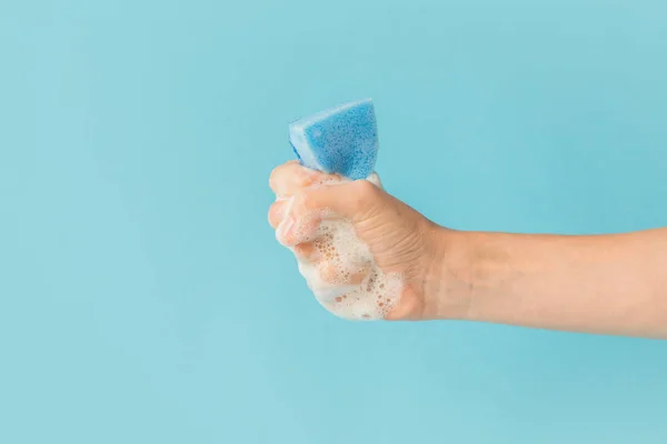 Vista Cortada Mão Segurando Esponja Lavagem Com Espuma Isolado Azul — Fotografia de Stock