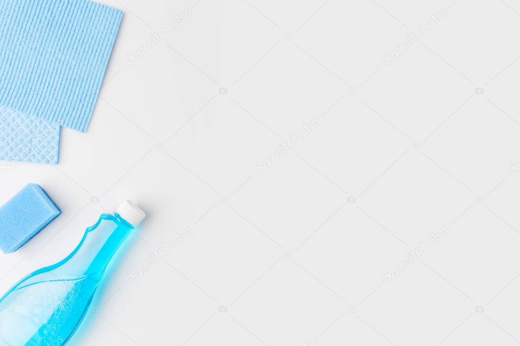 top view of blue washing sponges and spray bottle, isolated on white