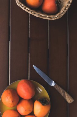 kahverengi masa üzerinde hasır sepet ve hurma ve bıçak ile plaka Üstten Görünüm 