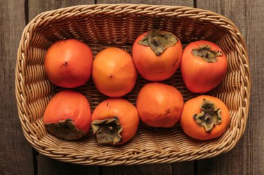 hasır sepet içinde iştah açıcı persimmons Üstten Görünüm tablo