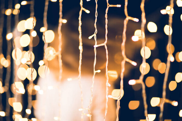 golden christmas garland with blurred woman moving on background