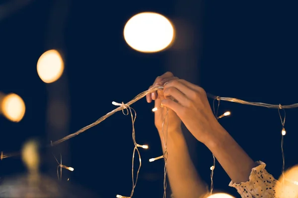 女人在黑色背景上悬挂美丽的花环 — 图库照片