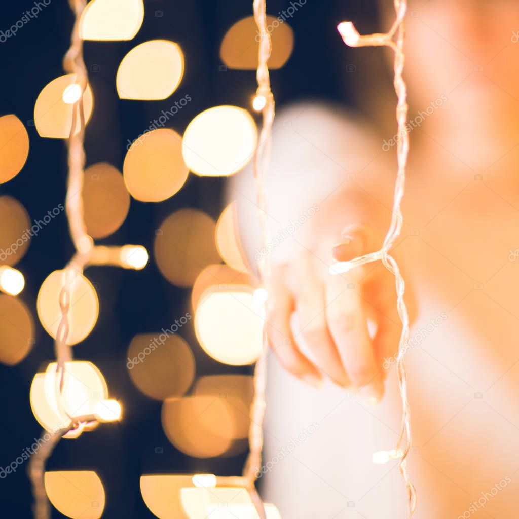 cropped shot of woman pointing at camera behind holiday garland