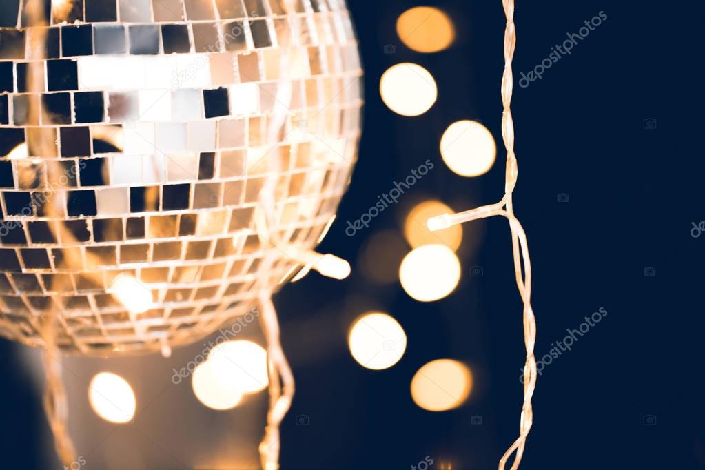 close-up shot of disco ball with garland on black background
