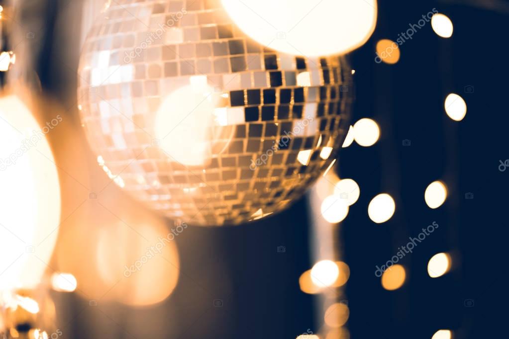 beautiful disco ball with golden garland on black