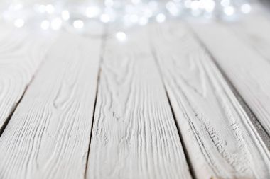 Beyaz ahşap yüzeyde şenlikli Noel bokeh ışıkları