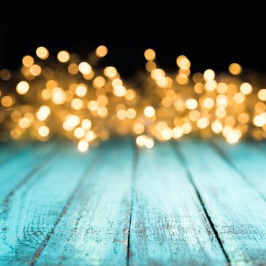 decorative bokeh lights on blue wooden surface, christmas background