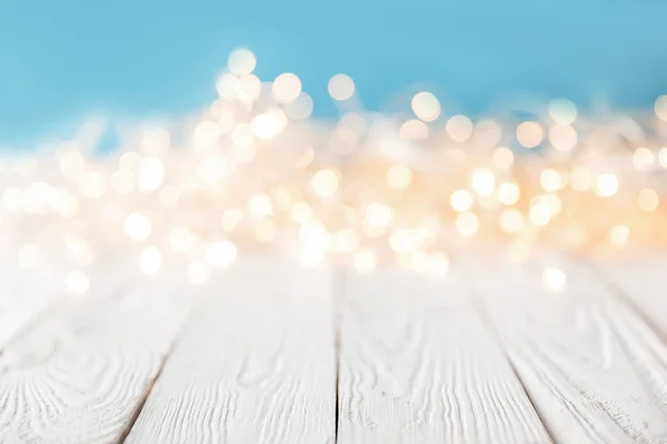Beyaz Ahşap Yüzey Noel Doku Üzerinde Bulanık Parlak Işıklar — Stok fotoğraf