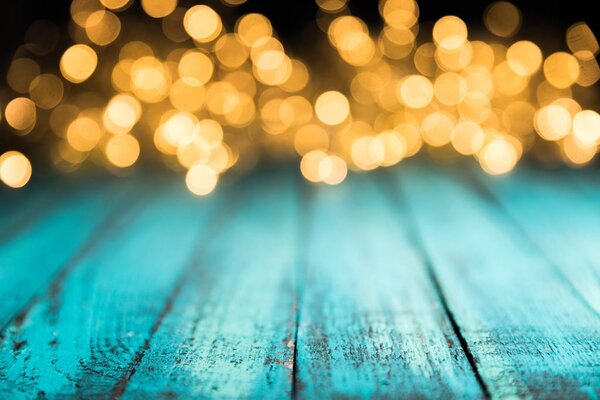 праздничные боке огни на голубой деревянной поверхности, рождественский фон
