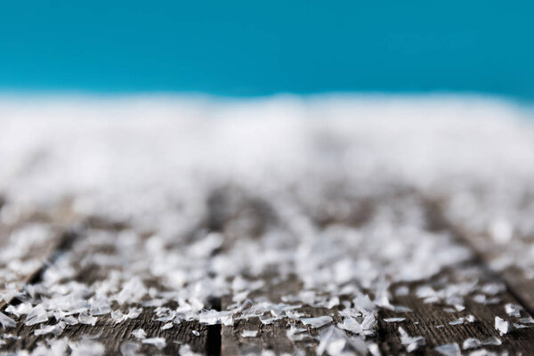 winter background with blurred snow on wooden surface