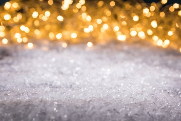 christmas winter background with snow and shiny blurred lights