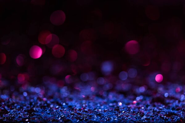 christmas background with blue and pink blurred shiny confetti stars 