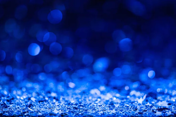 christmas background with blue blurred shiny confetti stars 