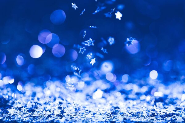 christmas background with falling blue shiny confetti stars