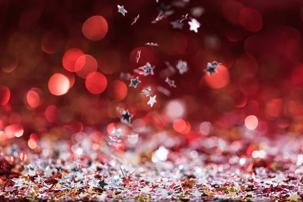 落ちてくる赤い光沢のある紙吹雪星とクリスマスの背景 — ストック写真