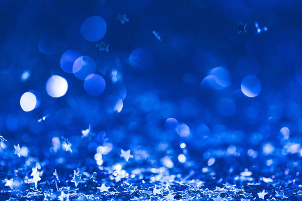 Рождественский фон с падающими голубыми блестящими конфетти звезд
