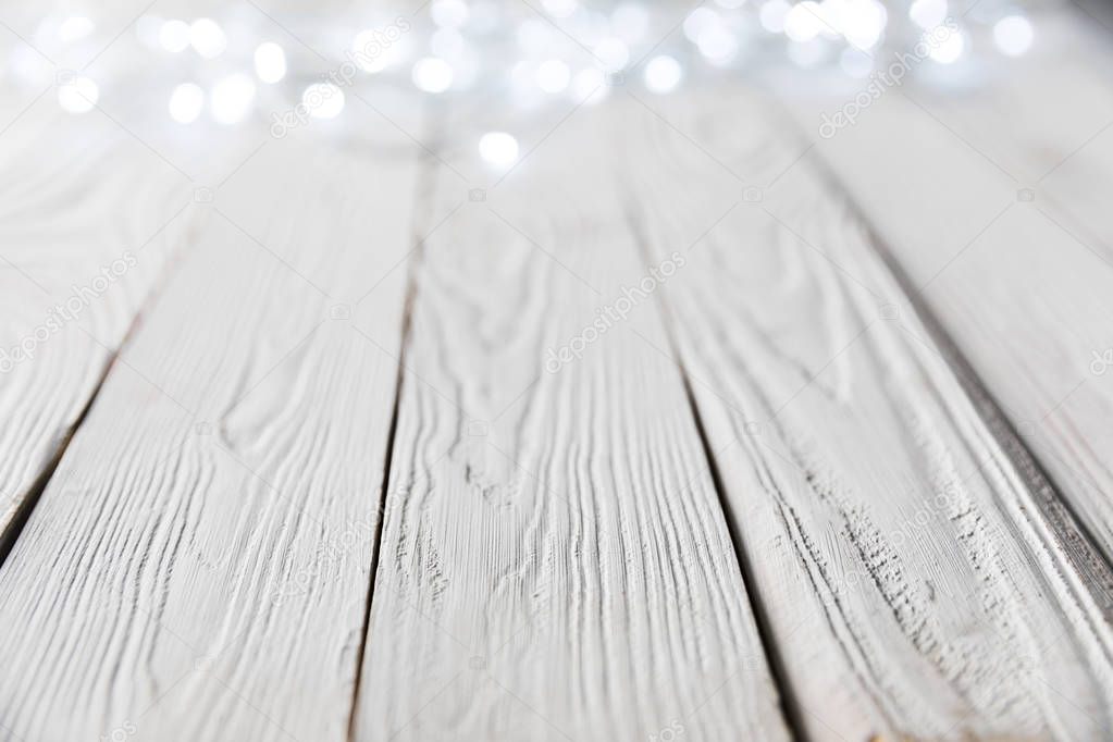 festive christmas bokeh lights on white wooden surface