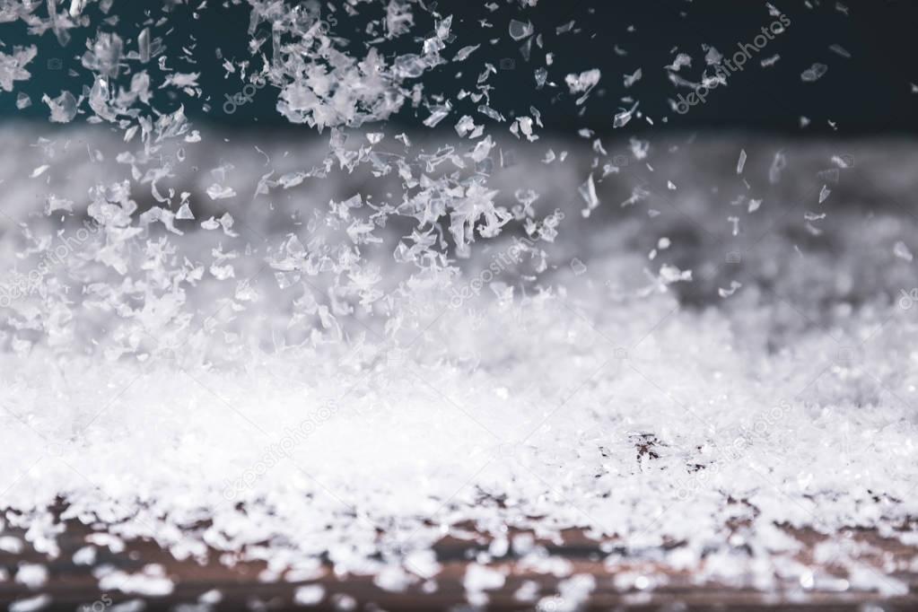 winter background with snow falling on wooden surface