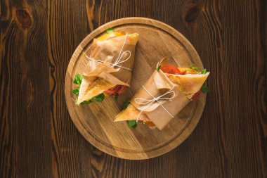 top view of two delicious panini on wooden round board  clipart