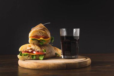 iki panini her diğer ve cola ahşap tahta üzerinde bardak 