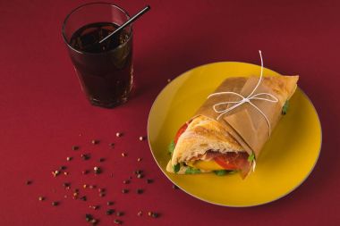 overhead view of panini on plate and glass of cola on table clipart