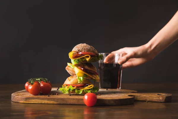 Imagem Cortada Mulher Tomando Copo Cola Mesa Com Grande Sanduíche — Fotografia de Stock