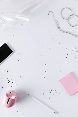 düz lay smartphone, pembe kumbara, yapışkan notlar ve üzerinde beyaz izole takı ile