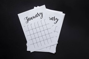 top view of arranged parts of paper calendar isolated on black clipart