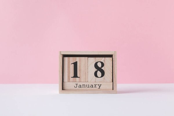close up view of wooden calendar isolated on pink