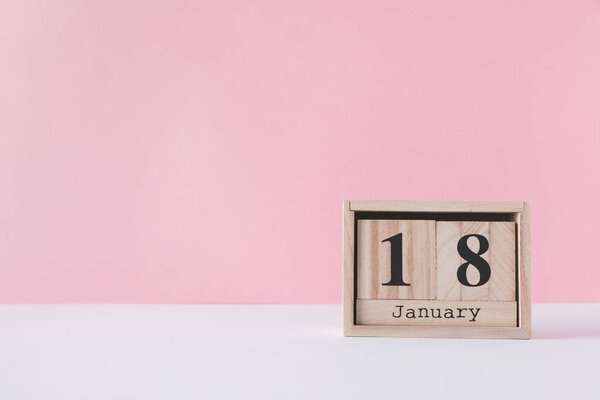 close up view of wooden calendar isolated on pink