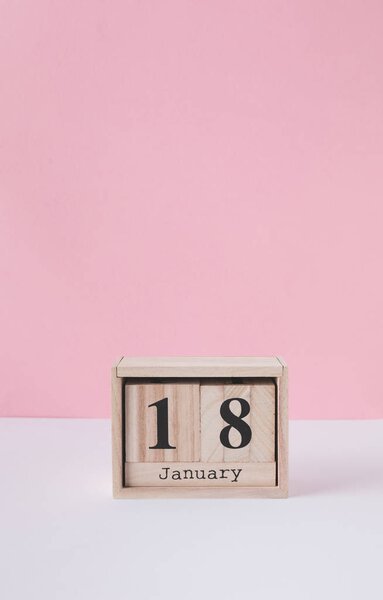 close up view of wooden calendar isolated on pink