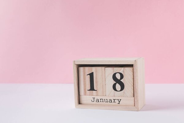 close up view of wooden calendar isolated on pink