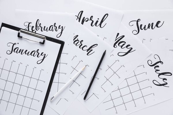 flat lay with calendar, notepad and pencils isolated on white