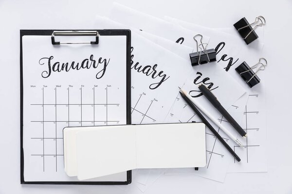 top view of arrangement of office supplies and calendar isolated on white