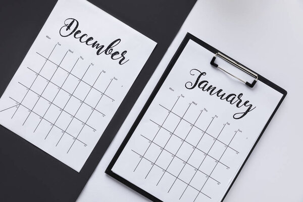 top view of notepad and calendar on black and white surfaces