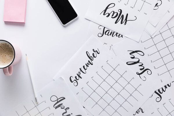 flat lay with calendar, smartphone, cup of coffee and sticky notes isolated on white