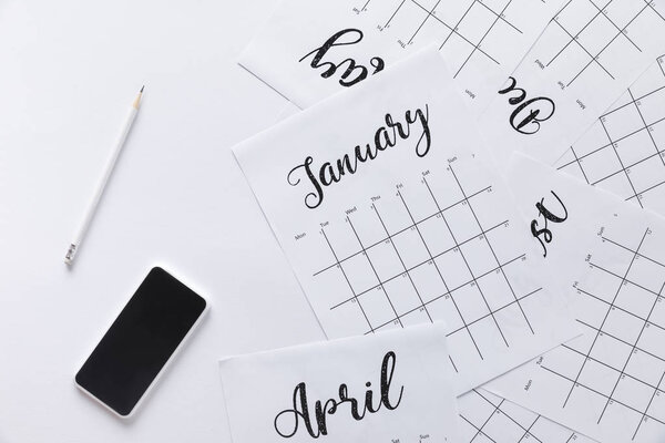 flat lay with calendar, smartphone and pencil isolated on white
