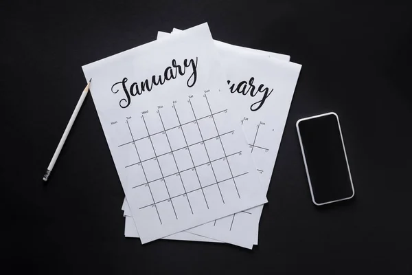 Posa Piatta Con Calendario Cartaceo Smartphone Matita Isolati Nero — Foto Stock