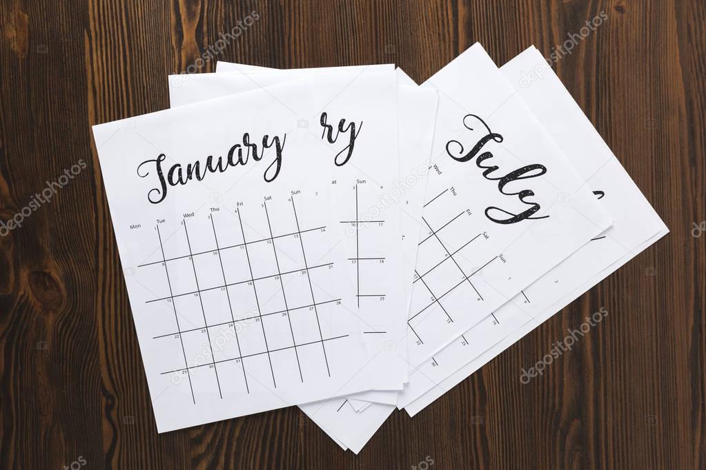 top view of pile of paper calendar parts on wooden tabletop