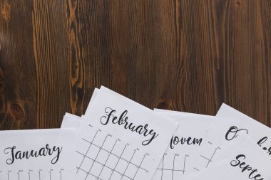 top view of paper calendar on wooden tabletop clipart