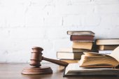 aufgerissene juristische Bücher mit Hammer auf Holztisch, Gesetzeskonzept