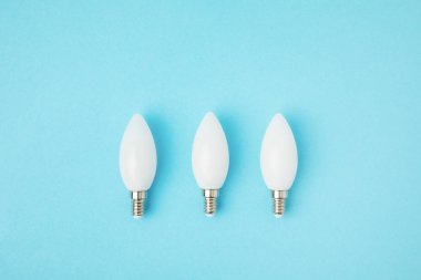 top view of white lamps arranged in line isolated on blue clipart