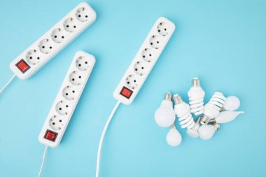 flat lay with extension cords and different light bubs isolated on blue clipart