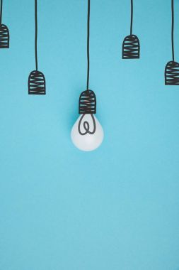 top view of light bulb pretending hanging on lamp holder isolated on blue clipart